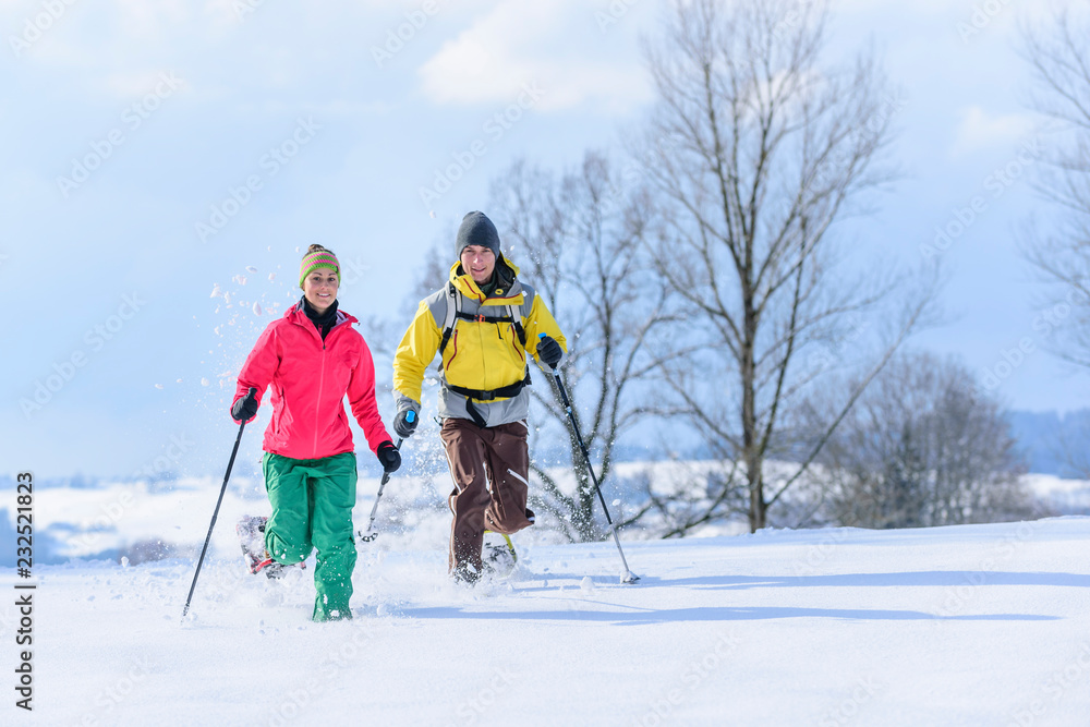 junge Leute haben Spaß im Schnee beim Schneeschuhwandern