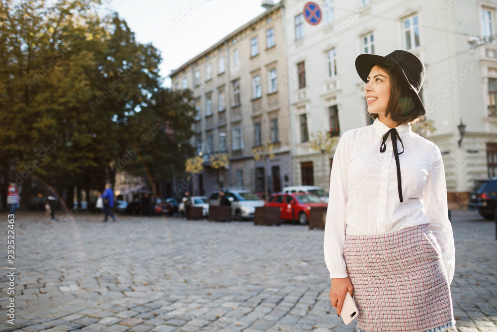 Portrait of a beautiful woman using mobile phone while standing on blurred street background. Portrait of a beautiful woman using mobile phone while standing on blurred street background.