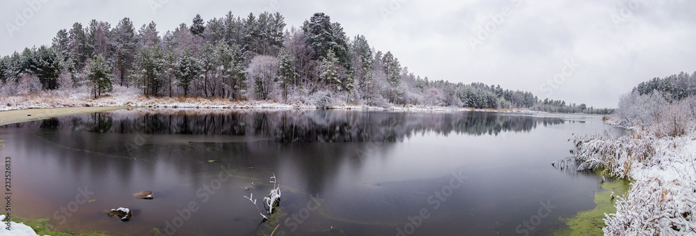 Fototapeta premium панорама пейзажа на Уральском озере с заснеженным лесом на берегу озера, Россия, ноябрь