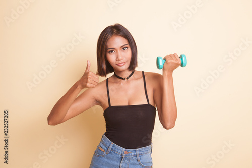 Healthy Asian woman thumbs up with dumbbells.
