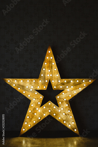The wooden star with light. Under a black background.