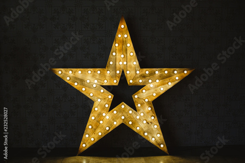 The wooden star with light. Under a black background.