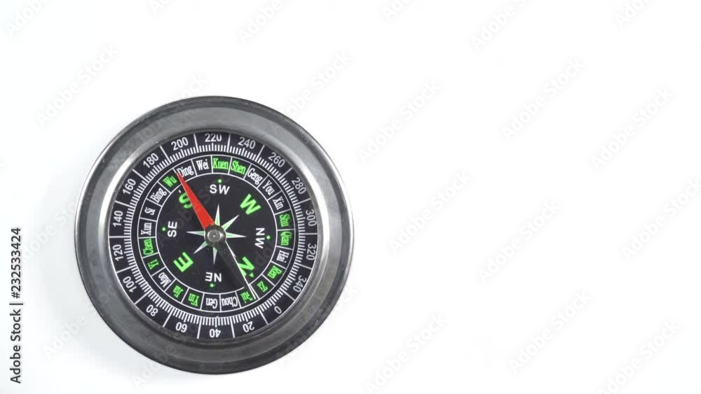 Black compass rotating on white background. Travel, tourism and exploration. Top down view Black compass rotating on white background. Travel, tourism and exploration. Top down view