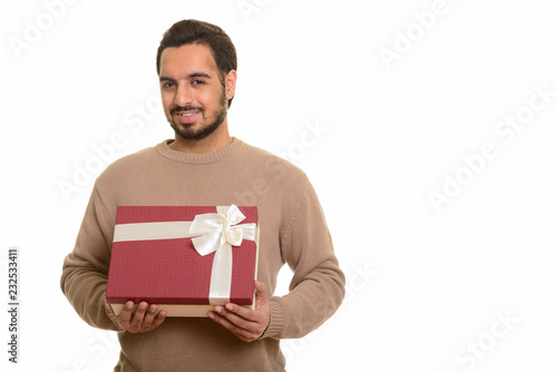 Young happy Indian man holding gift box ready for Valentine's da