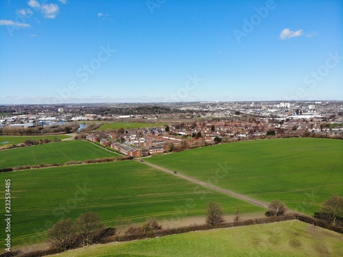 Aerial shot of a town in the UK overlooking a farmers field.