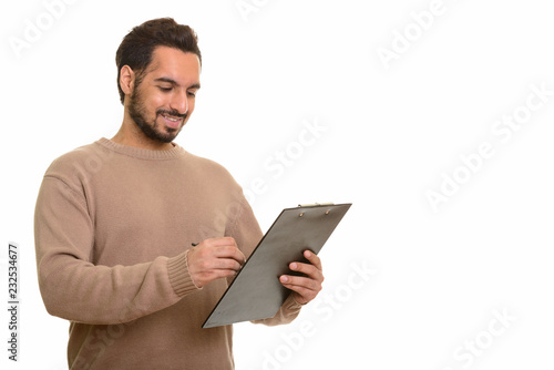 Young happy Indian man writing report on clipboard © Ranta Images