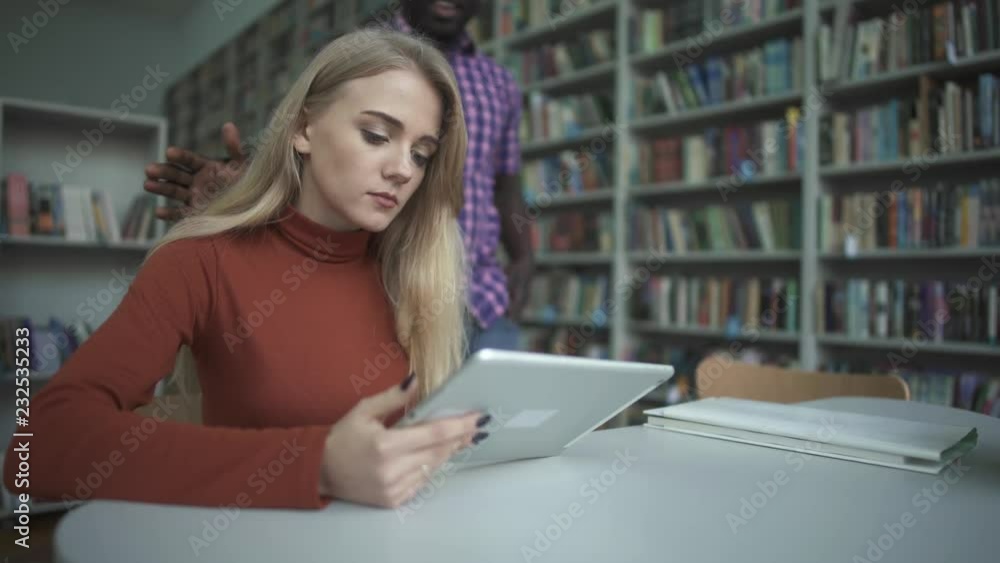 African american man and caucasian woman have met in the library African american man and caucasian woman have met in the library
