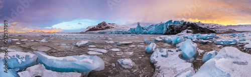 Famous Fjallsarlon glacier and lagoon with icebergs swimming on frozen water. photo