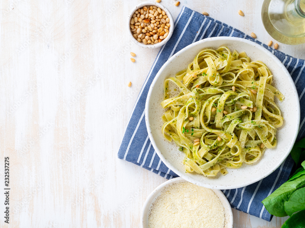 Tagliatelle pasta with pesto sauce made of Basil, garlic, pine nuts, olive oil. Top view, copy space