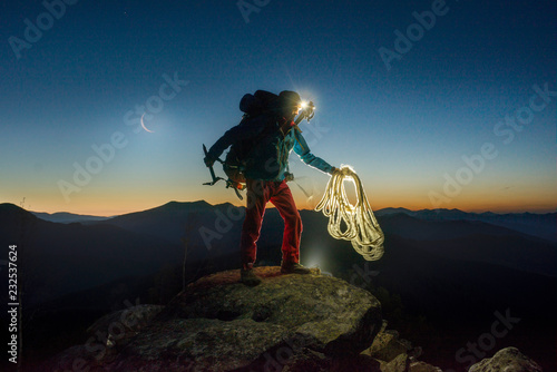 Climber at the top of the mountain at night.
