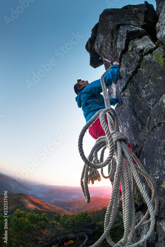 Climber at the top of the mountain at night. photo