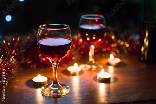 Glasses with red wine. Garlands in the background.