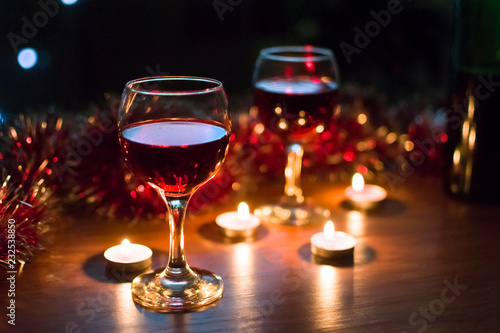 Glasses with red wine. Garlands in the background.