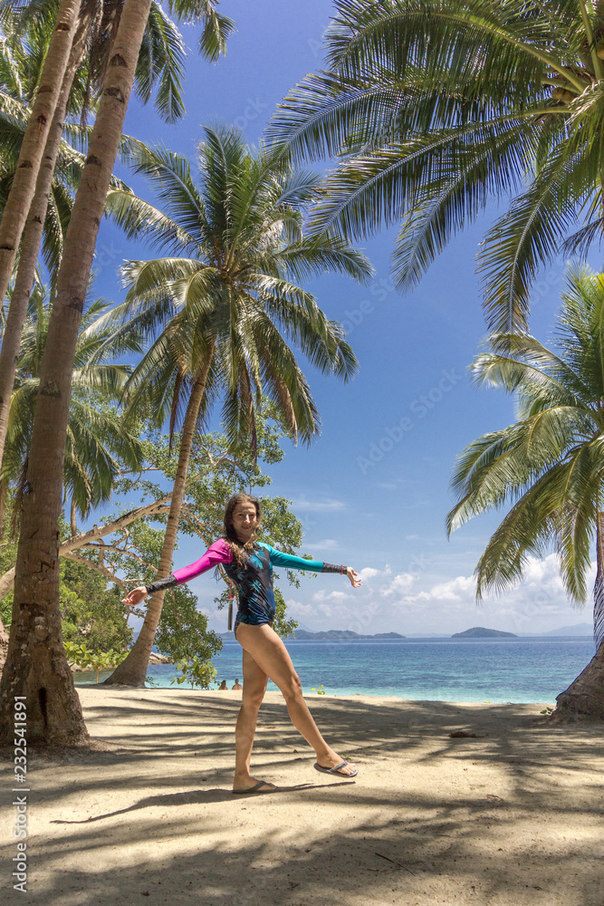 Woman walk on the tropical island with palms tree on the beach. Asian travel to the Philippine islands Woman walk on the tropical island with palms tree on the beach. Asian travel to the Philippine islands