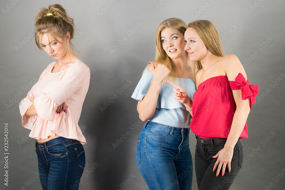Woman being gossiped by two females Woman being gossiped by two females