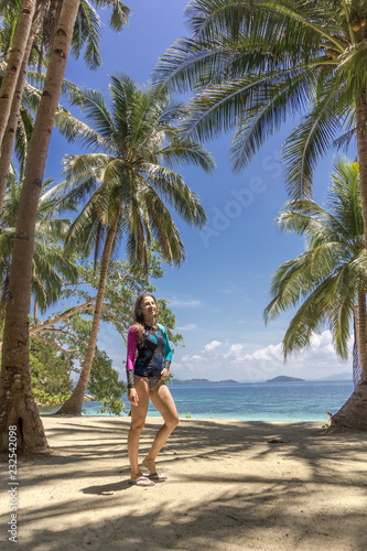 Woman pose on the tropical island with palms tree on the beach. Asian travel to the Philippine islands © Sokirlov