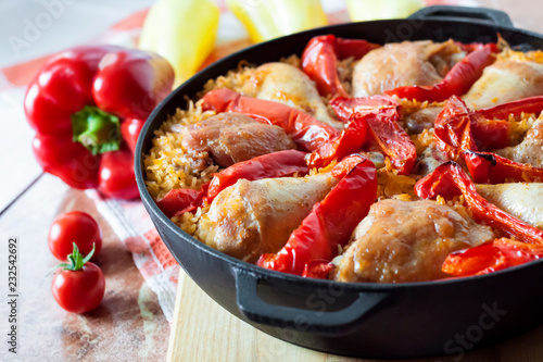 Chicken thighs and legs baked over a bed of rice and red bell pepper