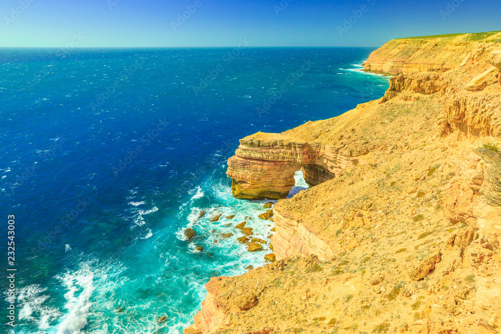 Aerial view from cliffs of Indian Ocean coastline at Natural Bridge lookout in Kalbarri National Park, Western Australia. Australian Outback travel. Blue sky, summer sunny day. Copy space.