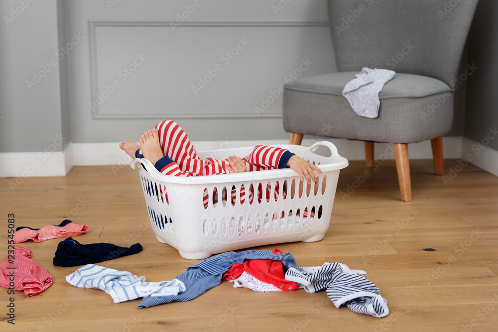 Funny baby hiding in laundry basket Stock Photo | Adobe Stock