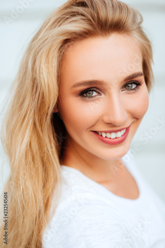 Portrait of blond young woman posing outdoors. Lifestyle