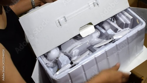 Woman unboxing a quad copter package bought and delivered from abroad