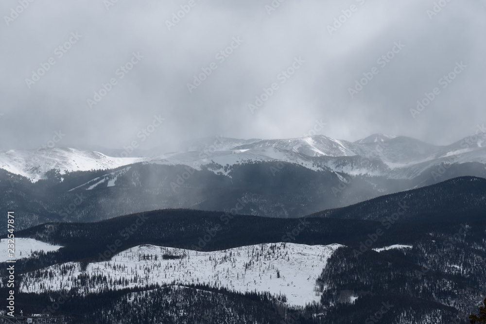 Mist rises as dramatic snowstorm moves across mountain valley