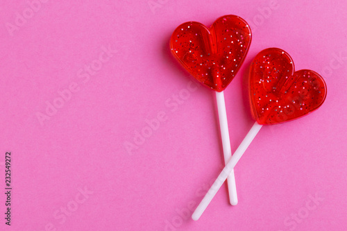 Two red sweet tasty lollipops in shape of heart