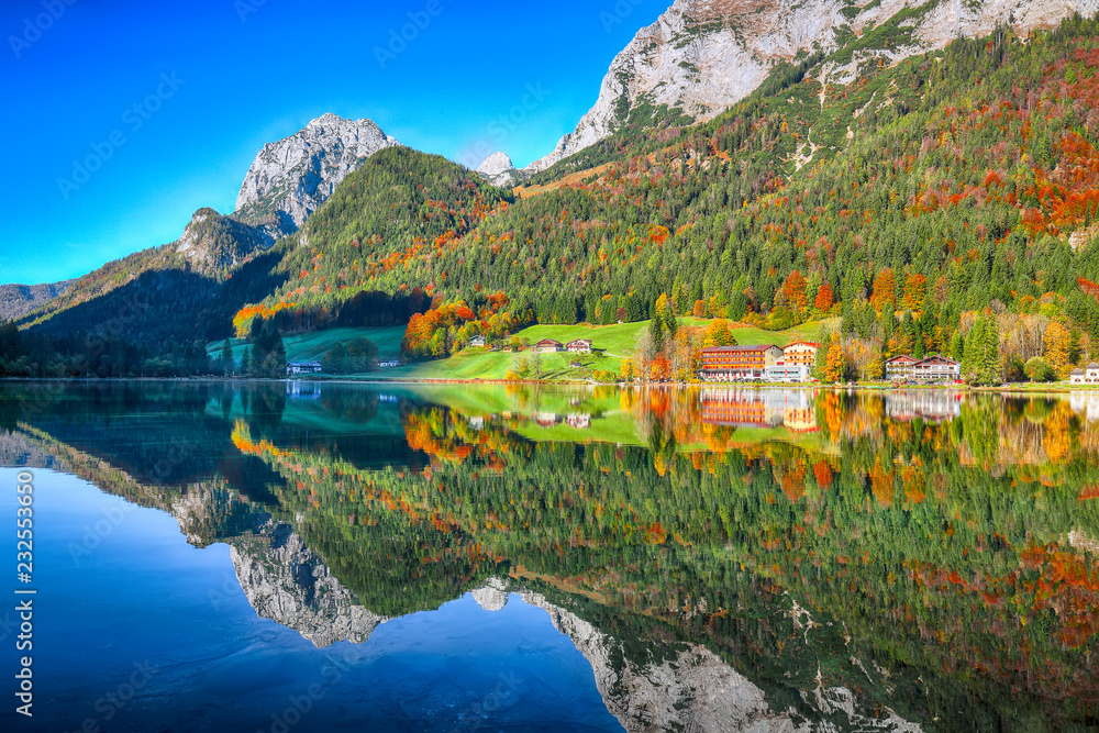 Fantastic autumn sunny day on Hintersee lake. Beautiful scene of mirror reflection in water
