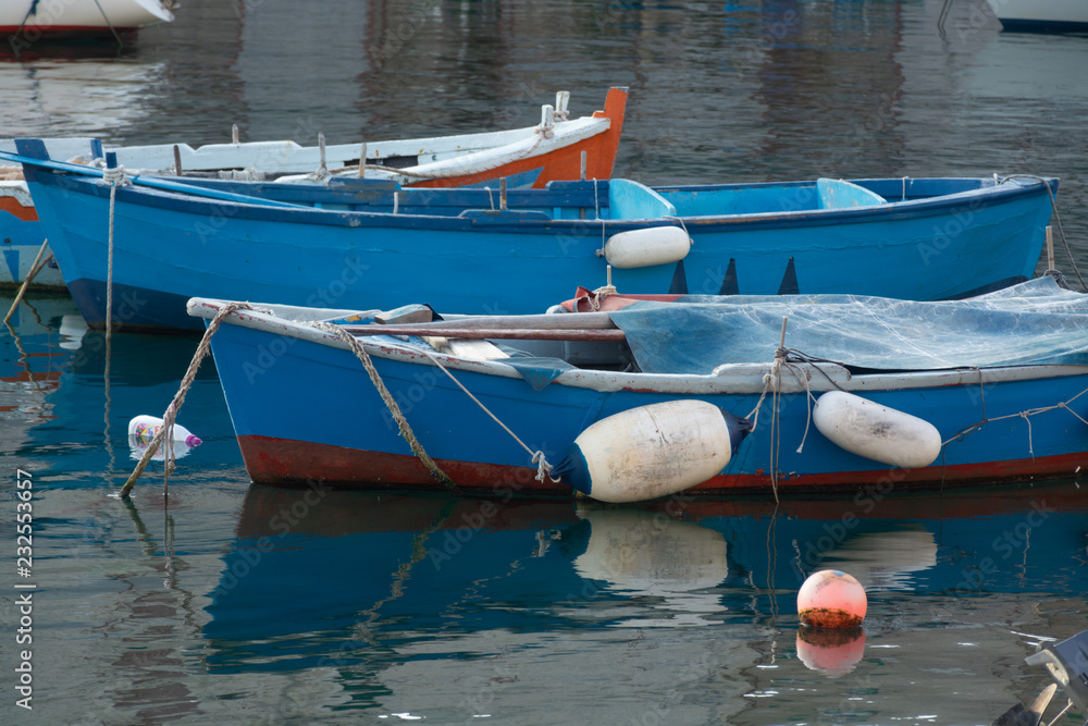 Obraz premium Old fishing harbor with colorful wooden boats in old small city Giovinazzo near Bari, Apulia, Italy in early morning