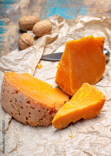 Pieces of native French aged cheese Mimolette, produced in Lille with greyish curst made by special cheese mites