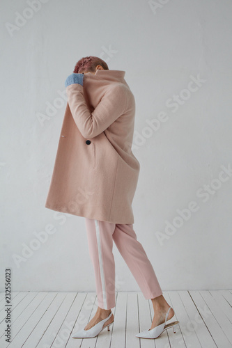 Anonymous model in elegant clothes posing on white background photo