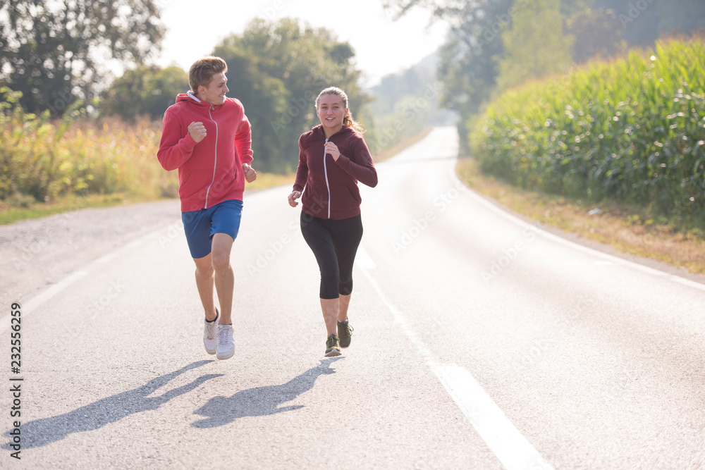 young couple jogging along a country road young couple jogging along a country road
