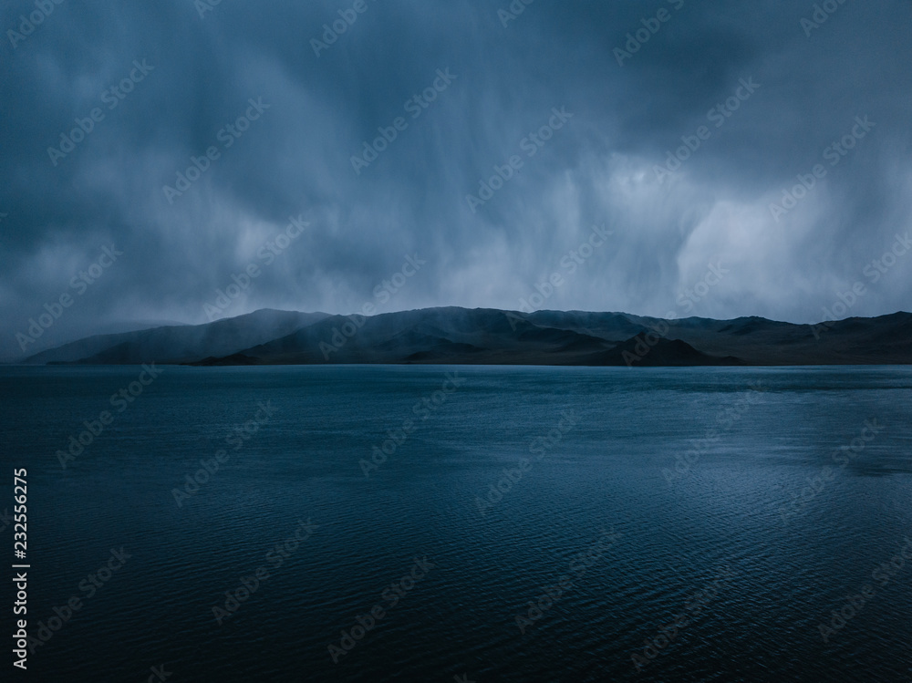 storm clouds above tolbo nuur lake with a mountain range in mongolia storm clouds above tolbo nuur lake with a mountain range in mongolia