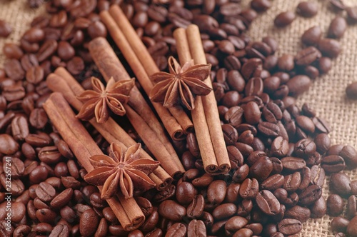 Aromatic roasted coffee beans and anis or badian, sticks of natural cinnamon on  background close up