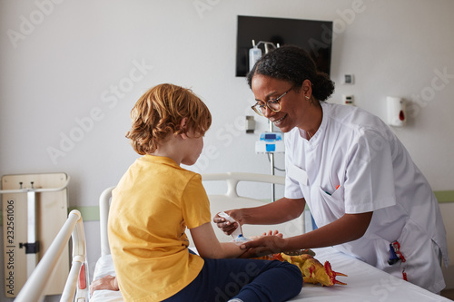Doctor female giving attention and care to child in a hospital room photo