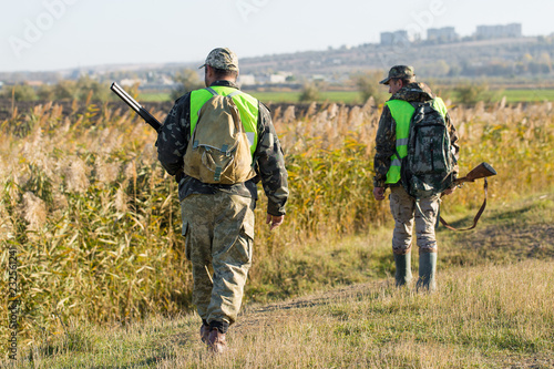 Hunters with a german drathaar and spaniel, pigeon hunting with dogs in reflective vests 