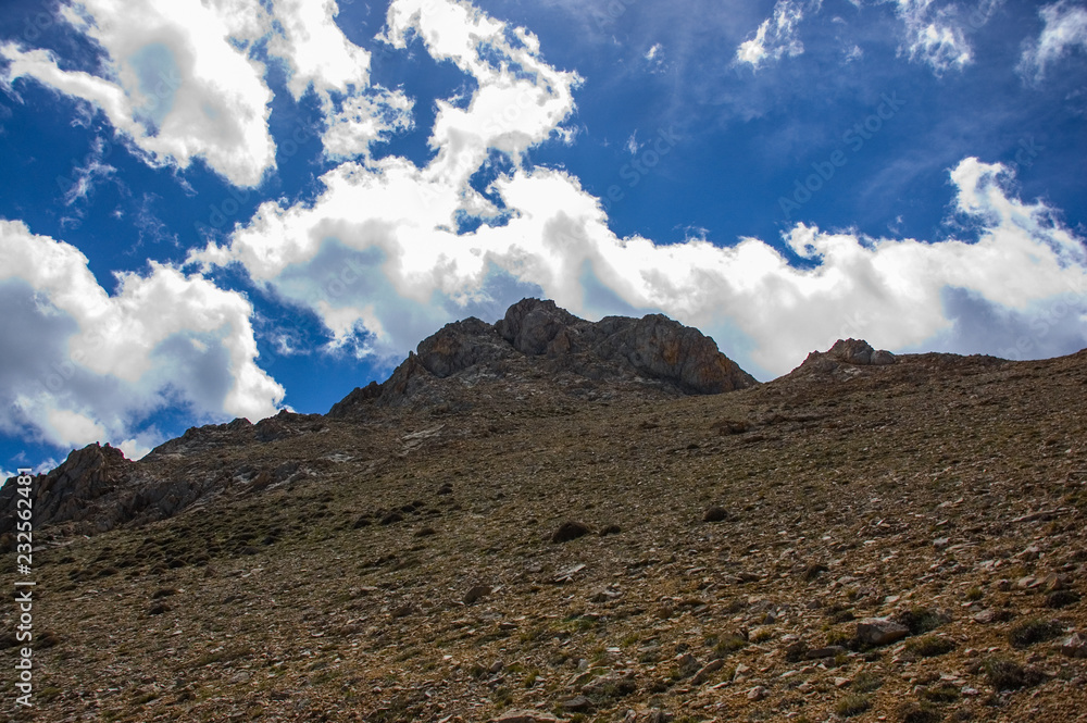 Landscape of mountain peak with blue sky and clouds.
