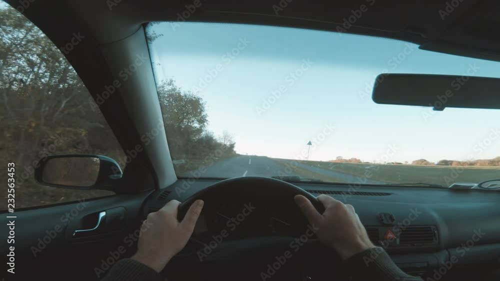 Point of view of one person driving car with hands on steering wheel Point of view of one person driving car with hands on steering wheel