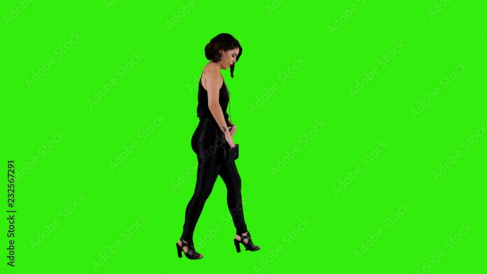 Pretty woman walking and texting, a date night or a girls night out look over a green screen in a long side shot. Pretty woman walking and texting, a date night or a girls night out look over a green screen in a long side shot.