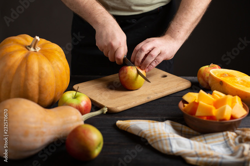 The cook cuts the apple into pieces for baking.