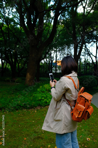 rear view of young woman standing against trees photo