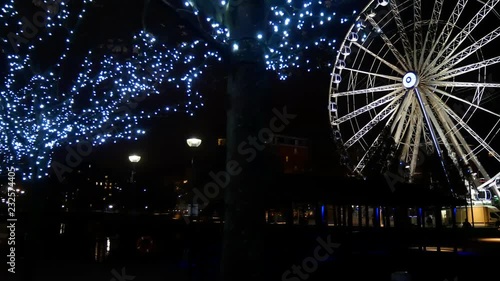 Dark night views of Echo arena & lit Ferris wheel in motion on the dock waterfront. photo