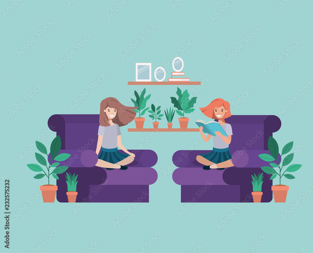 student girls sitting reading book in livingroom student girls sitting reading book in livingroom