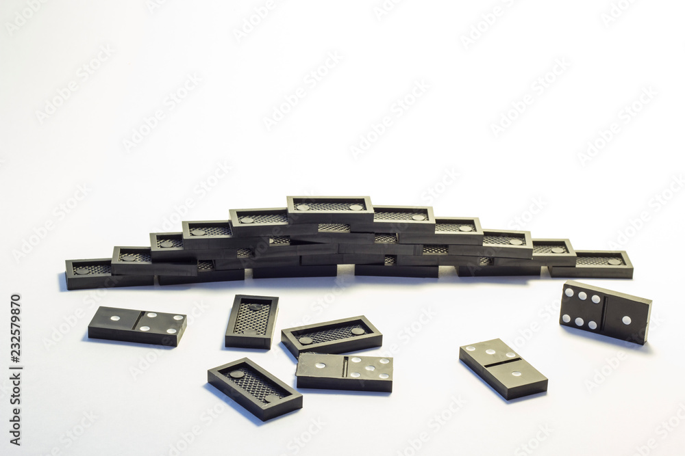 Knuckles of black dominoes are combined in a pyramid on a white background Knuckles of black dominoes are combined in a pyramid on a white background