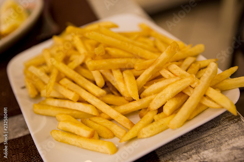 Plate of golden french fries in a restaurant in Italy