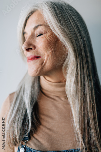 Portrait of a smiling senior woman with grey long hair.