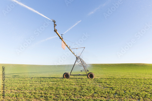 Agricultural sprinkler spraying water on a field