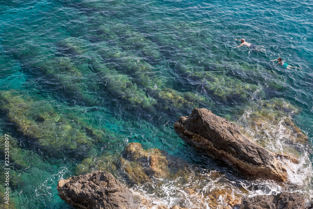 Swimming in the crystal clear water and rocks at Monterosso al Mare on the Ligurian coast in Italy Swimming in the crystal clear water and rocks at Monterosso al Mare on the Ligurian coast in Italy