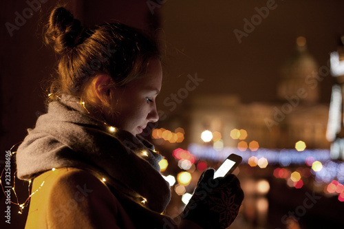 Young woman using phone at night photo