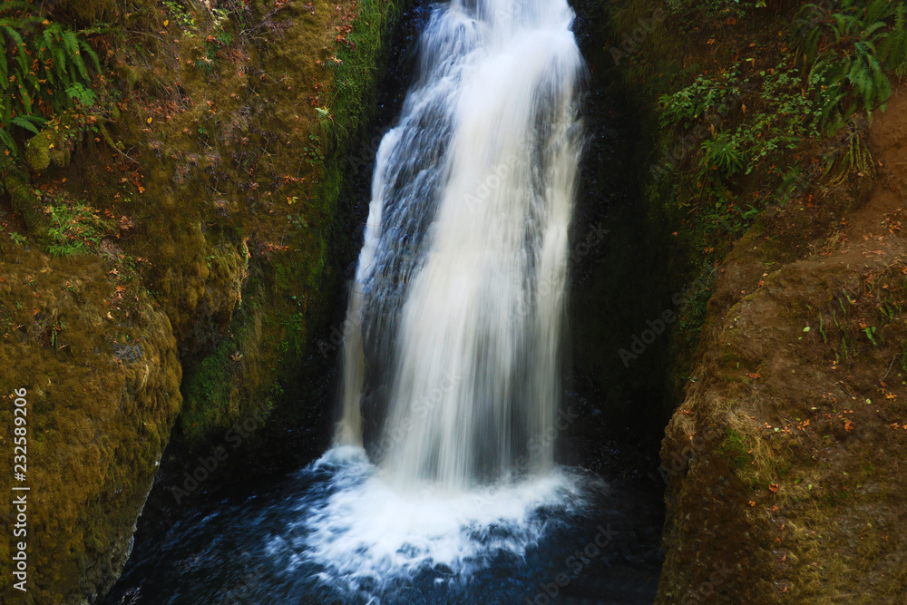 Naklejka premium View of a small waterfall on a sunny day